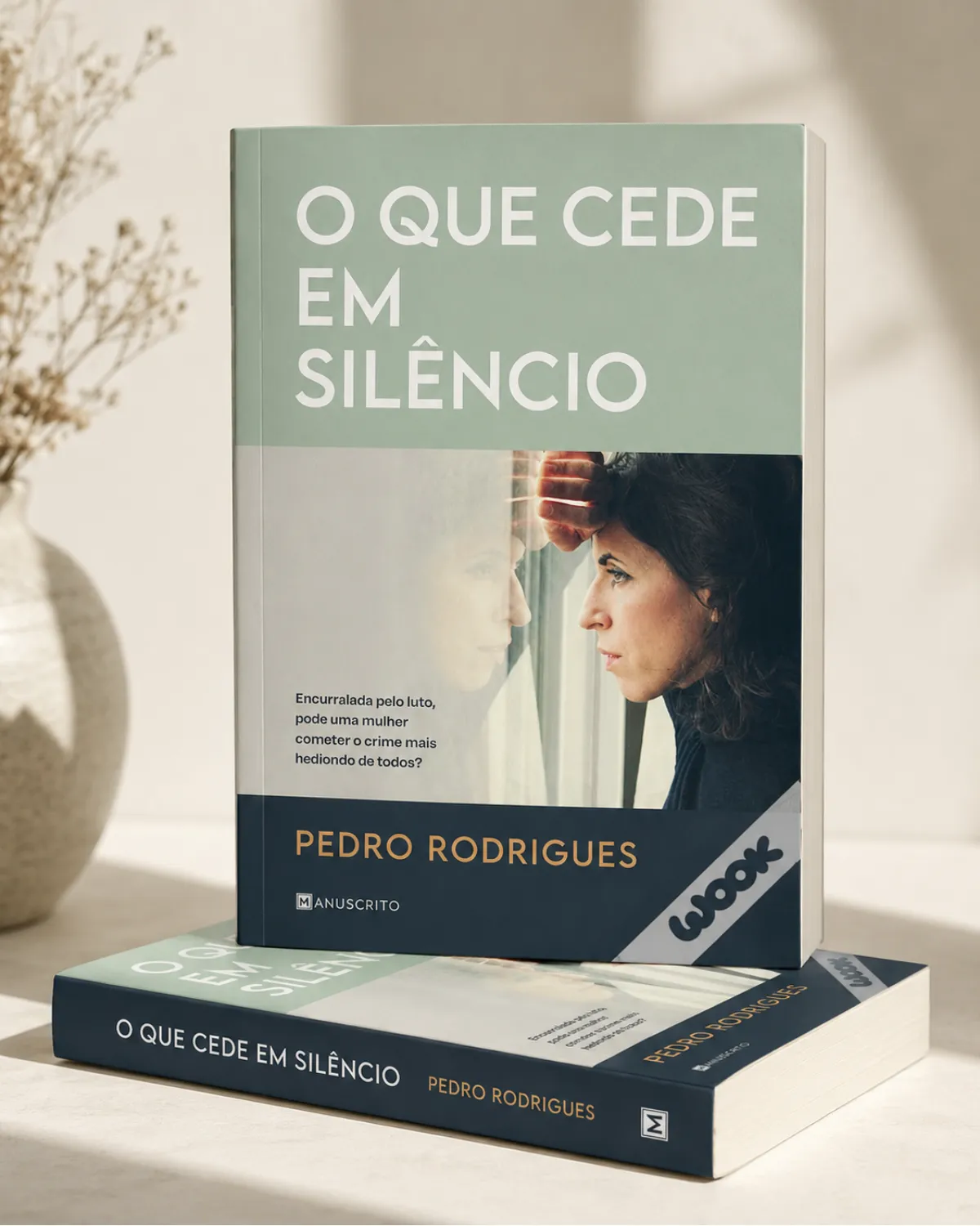 Fotografia do romance O Que Cede em Silêncio, de Pedro Rodrigues, publicado pela Manuscrito, com dois exemplares do livro.